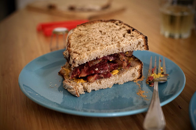 Montreal smoked meat sandwich in rye flour bread with yellow mustard